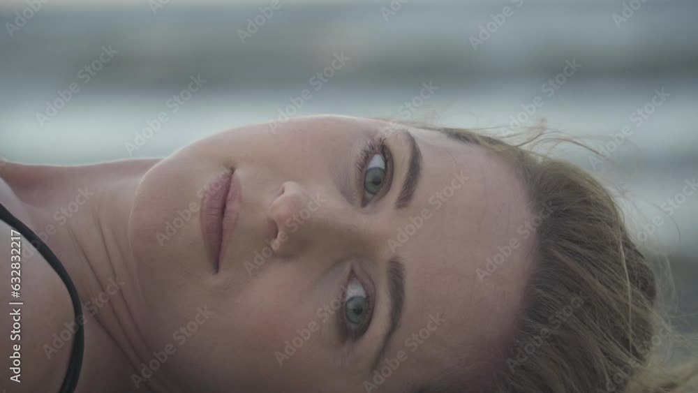 Close up of attractive young woman laying and looking at the camera Close up of attractive young woman laying and looking at the camera