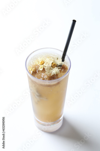 homemade boiled cook ice cold chilled yellow Chrysanthemum flower healthy tea in tall glass white background beverage halal food vegan menu for cafe
