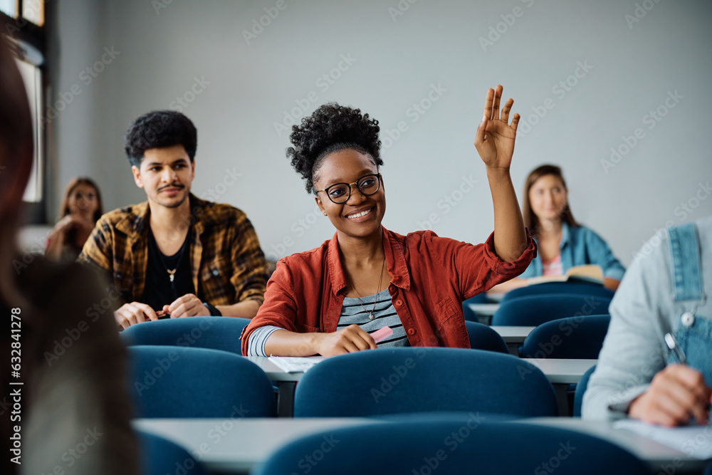 Happy black student raising her hand to ask question during class at university. - obrazy, fototapety, plakaty 