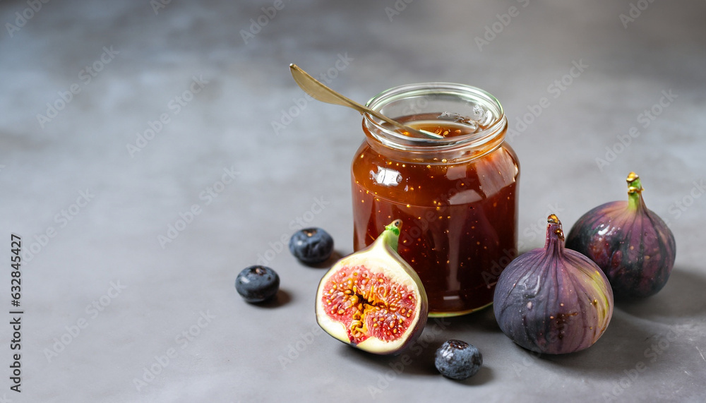 Fig jam in glass jar with fresh blue figs. Homemade preparations and canning. Gray background, copy space Fig jam in glass jar with fresh blue figs. Homemade preparations and canning. Gray background, copy space