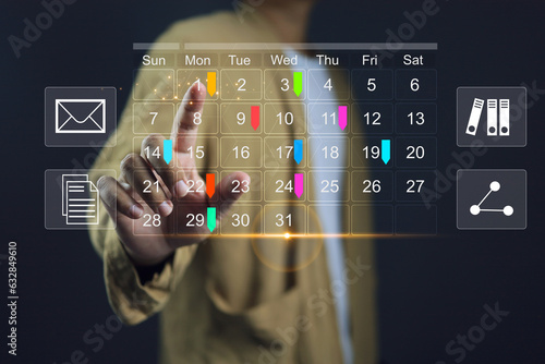 Reminder appointment calendar for organizer agenda time table and event planner organize and schedule activity. Man pointing on calendar or schedule to marking color paper note target date appointing. photo