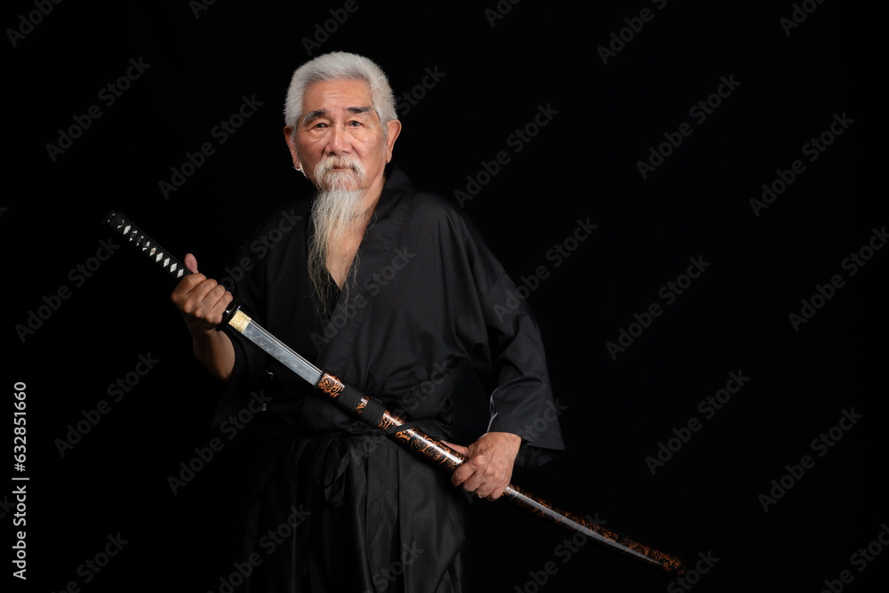 Senior Japanese samurai with katana sword on black background, studio shot Senior Japanese samurai with katana sword on black background, studio shot