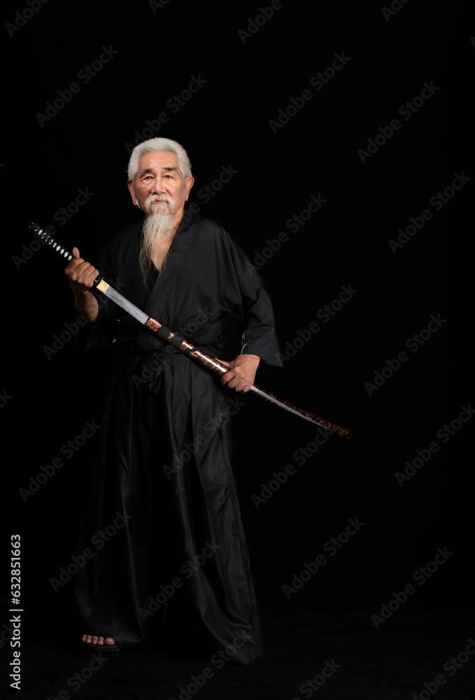 Senior Japanese samurai with katana sword on black background, studio shot Senior Japanese samurai with katana sword on black background, studio shot
