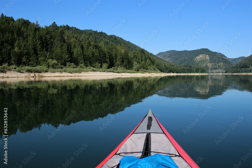 first person kajak on a lake with mountains in the background