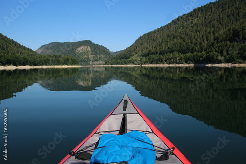 first person kajak on a lake with mountains in the background