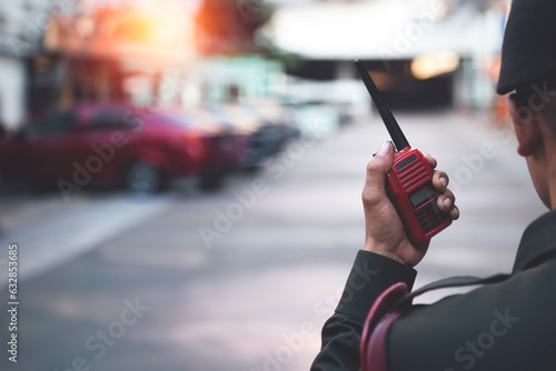 Security guard uses radio communication for facilitate traffic. Traffic Officers use walkie talkie to maintain order in the parking lot in Thailand..