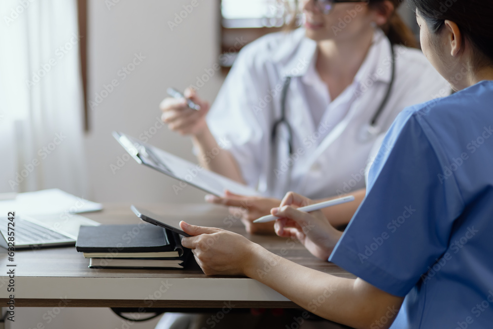 Two female doctor working at desk in clinic office, Teamwork in medicine and healthcare concept. Two female doctor working at desk in clinic office, Teamwork in medicine and healthcare concept.