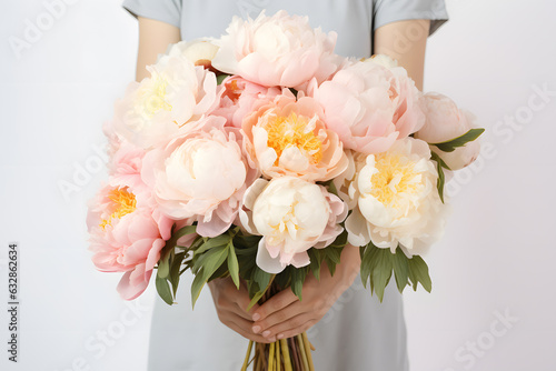 Woman hands holds a bouquet of many colored peonies isolated on white background © Oksana