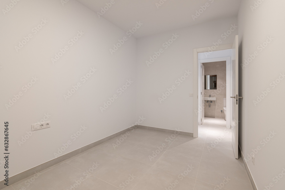 Empty white room with an open door - access to the bathroom. The concept of selling housing in a new building or an apartment after renovation Empty white room with an open door - access to the bathroom. The concept of selling housing in a new building or an apartment after renovation