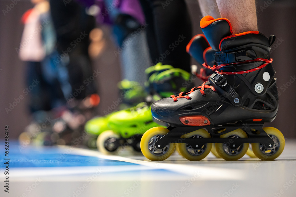 Close-up of roller skates of people training figure skating in a sports hall. Photo taken with artificial lighting of the sports hall.