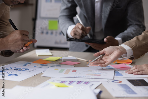 Group of business team working with analysis financial data visualization tech for marketing strategy, Businesswoman accountant or financial report graph at desk in corporate office. 