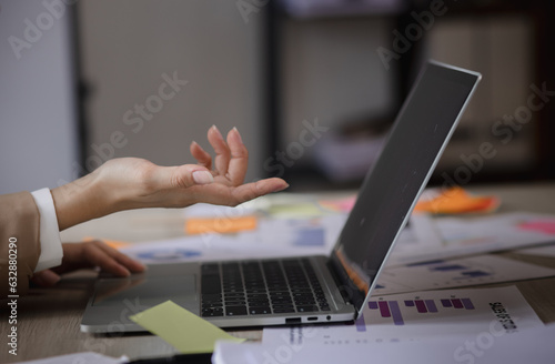 Business hands using laptop computer with document analysis data statistics on office desk. business documents and graph financial diagram.