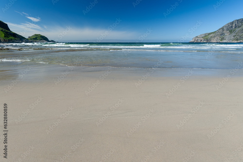 beach sand and waves against a blue sky