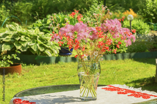 In a glass vase on a garden table, a summer fresh bouquet of flowers.