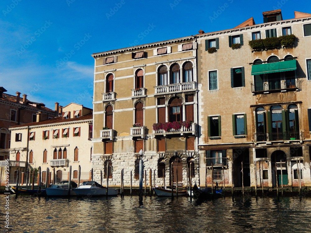 Old and historical Venetian houses with canal waterfront landscape and moored modern boats in Venice Italy