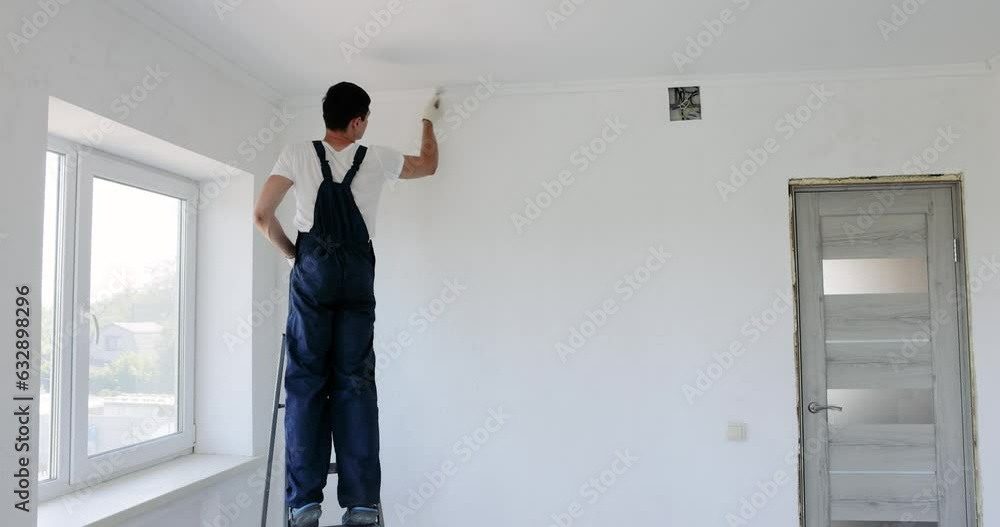 man painting wall in white color with roller man painting wall in white color with roller