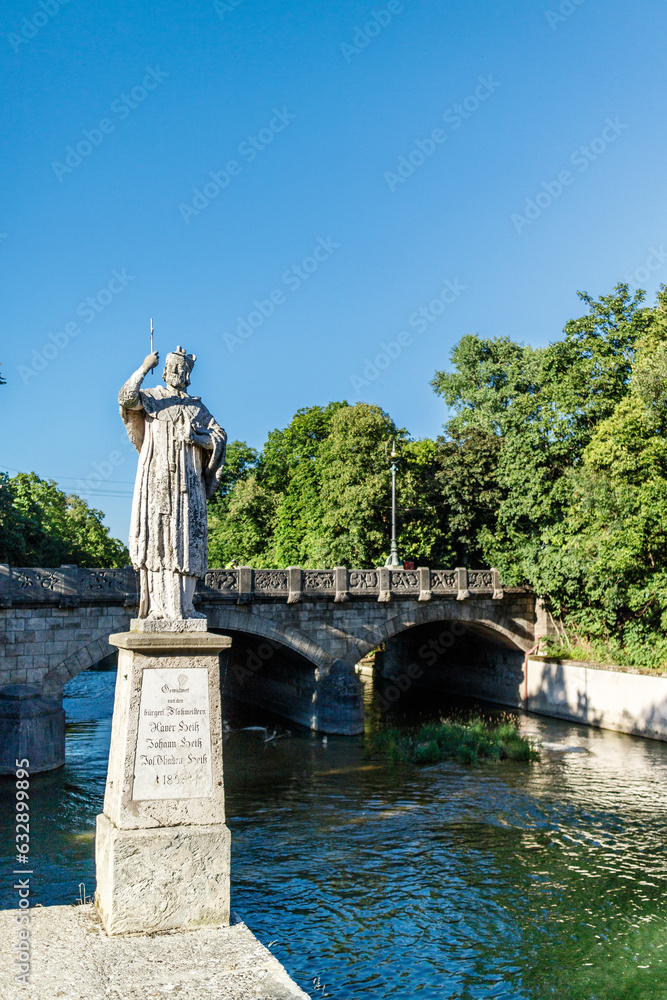 Statue of ruler on stone platform near river