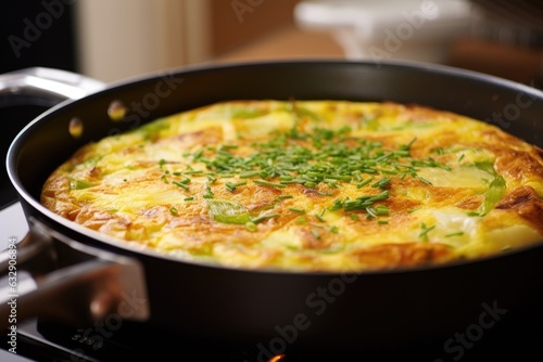 hot, golden-brown frittata cooling on stovetop photo