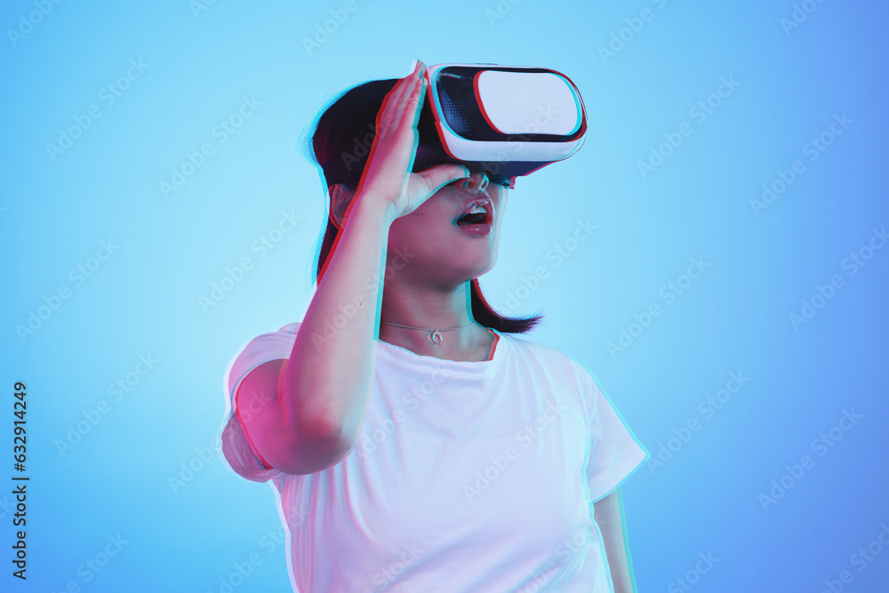 Woman, VR and vision with wow for futuristic experience, 3d games and gen z education or digital e learning. Student with surprise for virtual reality, high tech and glasses on blue studio background Woman, VR and vision with wow for futuristic experience, 3d games and gen z education or digital e learning. Student with surprise for virtual reality, high tech and glasses on blue studio background
