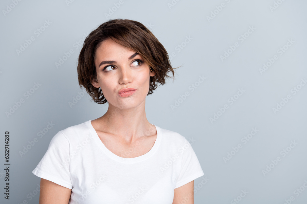 Photo of suspicious pretty woman dressed white t-shirt looking empty space isolated grey color background Photo of suspicious pretty woman dressed white t-shirt looking empty space isolated grey color background