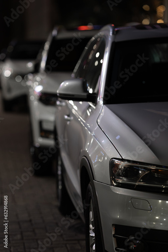 Cars standing in a row at night in parking © VERSUSstudio
