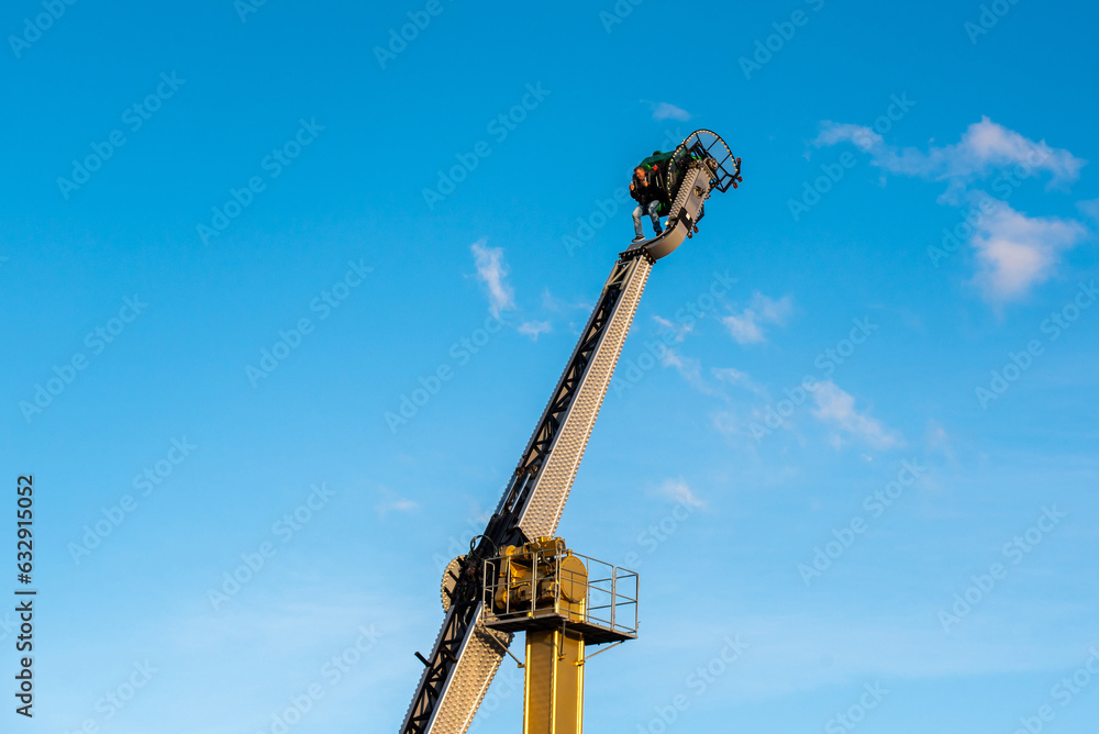 Attraction - a vertical carousel with a person inside, the person's face is blurry Attraction - a vertical carousel with a person inside, the person's face is blurry