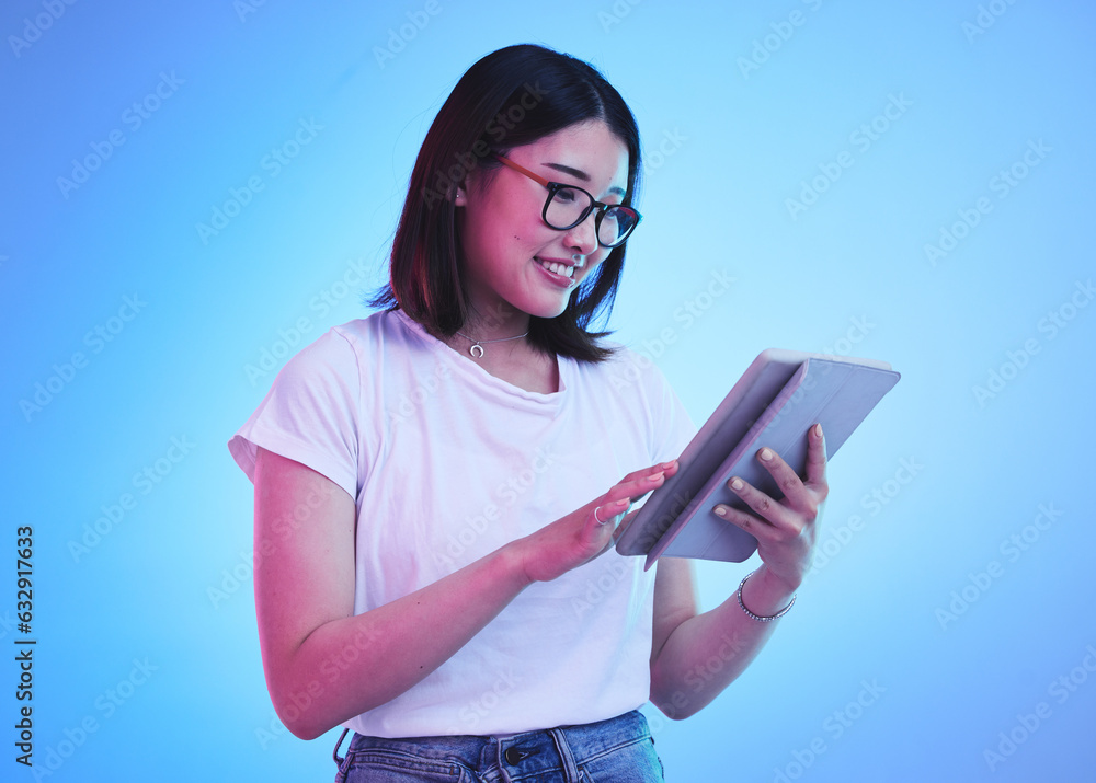 Young woman, student and tablet for online education, e learning and study on blue, studio background. Happy person typing on digital technology, reading social media and school or youth information Young woman, student and tablet for online education, e learning and study on blue, studio background. Happy person typing on digital technology, reading social media and school or youth information