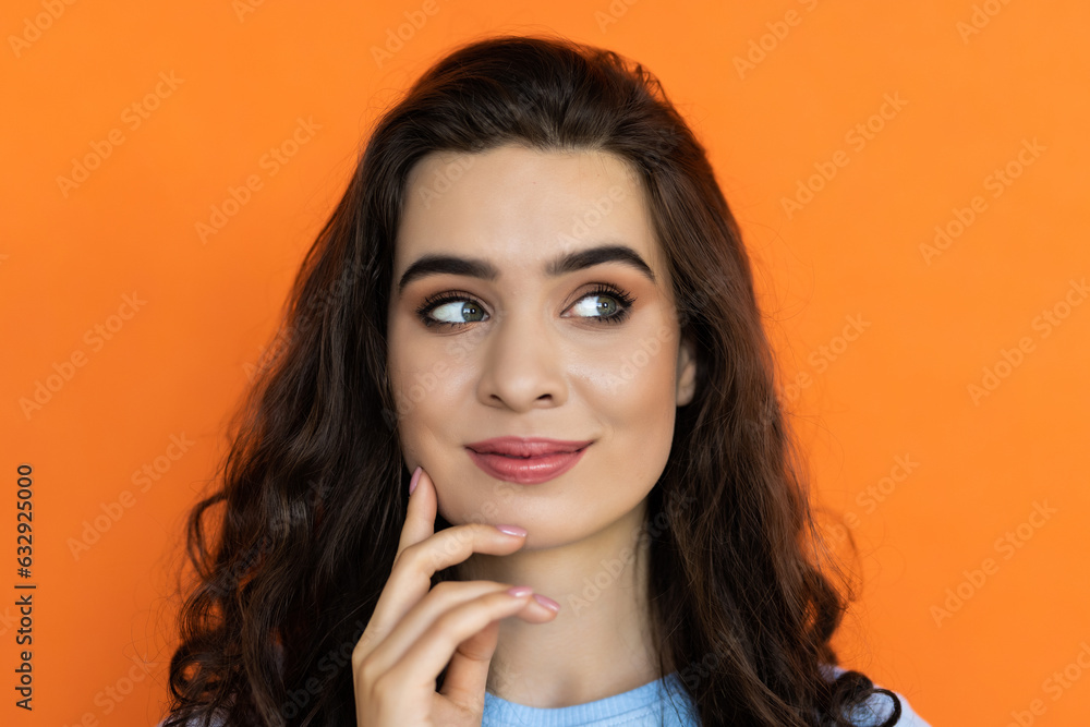 Female smiling with folded hands isolated on bright orange color background Female smiling with folded hands isolated on bright orange color background