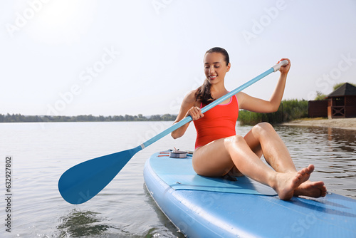 Woman paddle boarding on SUP board in sea, space for text