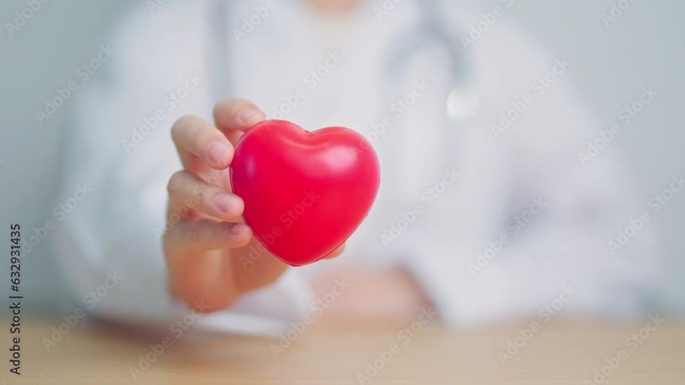 Doctor hand holding red heart shape in hospital. love, donor, world heart day, world health day, CSR donation and Insurance concepts Doctor hand holding red heart shape in hospital. love, donor, world heart day, world health day, CSR donation and Insurance concepts