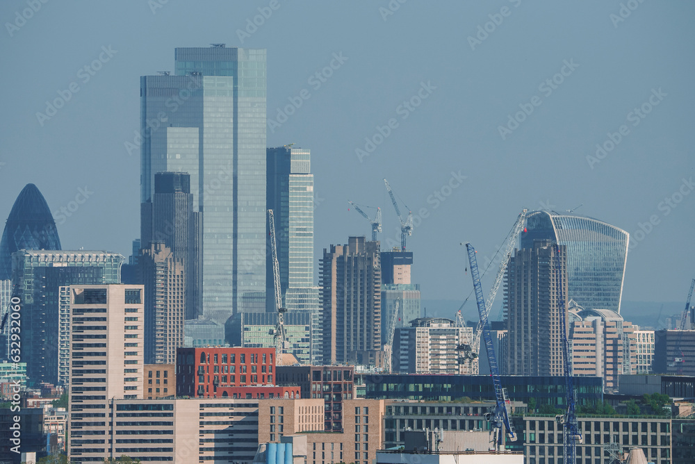 View of famous financial skyscrapers amidst residential district. Modern city with blue sky in background. High angle view of urban development in London.