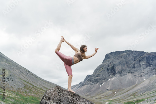 Asana pose harmony with nature mountain background, Meditation and mental health of a person. Diet and exercise. The trainer is engaged in pilates asana and stretching a slim body. 