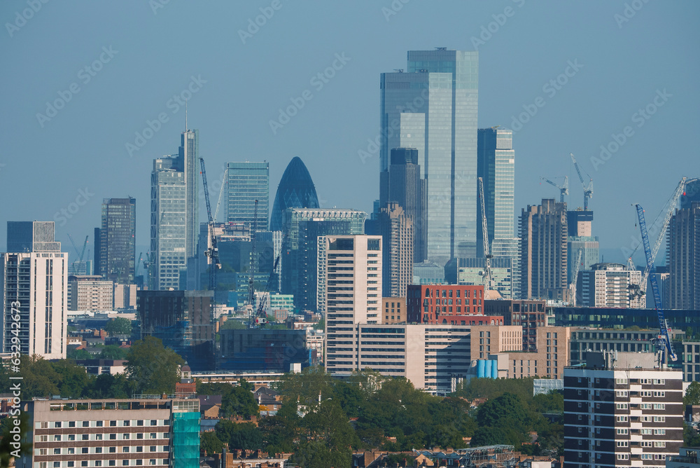 Obraz premium Scenic view of crowded cityscape with blue sky in background. Tall skyscraper amidst residential buildings. High angle view of modern development in London.