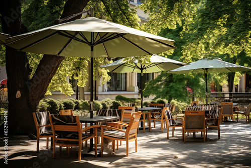Restaurant, cafe, bar, terrace in the city in the shade and under of trees and parasols © PHdJ