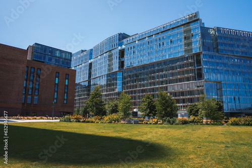 Residential building at Battersea with sky in background. Modern apartment with glass windows on sunny day. View of grassy field in front of beautiful architecture at city.