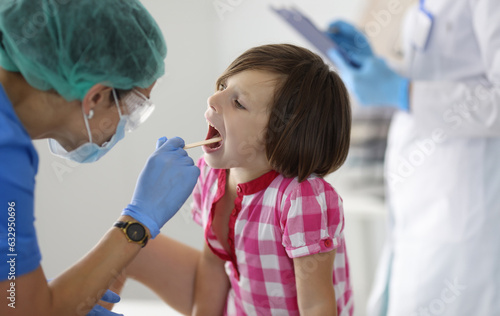 Canvas Print Little girl's throat is examined at doctor's appointment