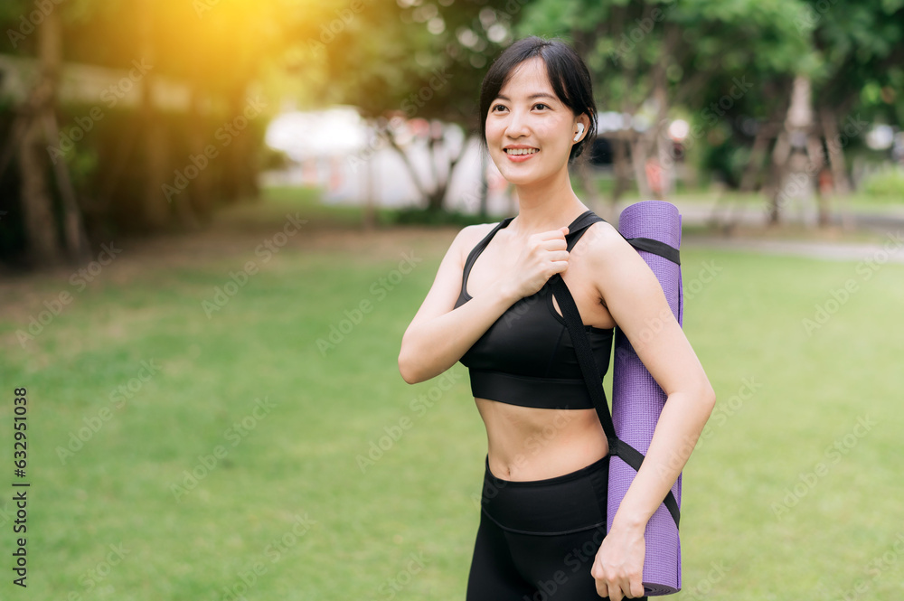 Yoga girl. Portrait of young asian slim and healthy girl doing workout in park, standing with rubber mat for exercises on green park at sunset, healthcare and well-being and yoga concept. Yoga girl. Portrait of young asian slim and healthy girl doing workout in park, standing with rubber mat for exercises on green park at sunset, healthcare and well-being and yoga concept.