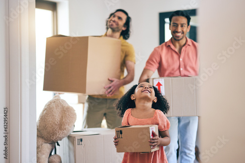 Happy, family and box moving with child and gay parents in new home with cardboard package. Smile, kid and lgbt people together with real estate and property mortgage in a house helping father photo