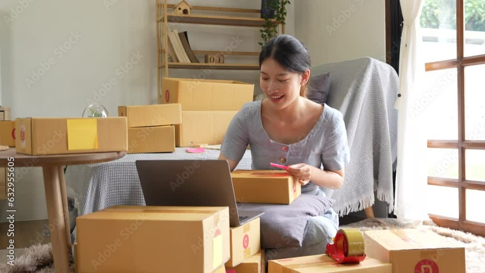 Young asian woman is using laptop computer checking order of customer with purchase online shopping, business SME or startup, entrepreneur or seller and service delivery product Young asian woman is using laptop computer checking order of customer with purchase online shopping, business SME or startup, entrepreneur or seller and service delivery product