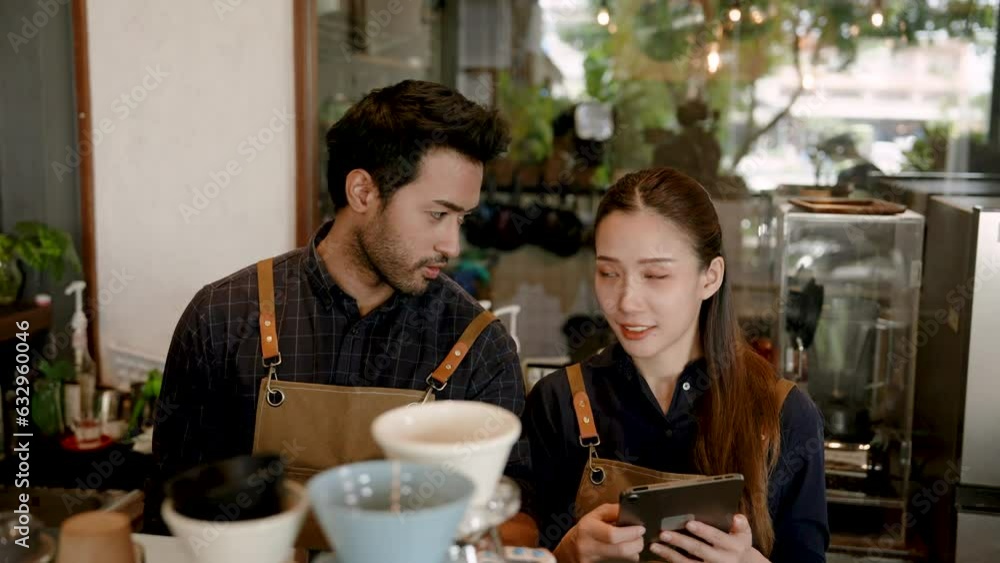 Coffee shop owner's barita takes orders from his wife. that customers order through an online application on a tablet Beautiful Asian woman and her Indian husband prepare to make coffee for customers Coffee shop owner's barita takes orders from his wife. that customers order through an online application on a tablet Beautiful Asian woman and her Indian husband prepare to make coffee for customers