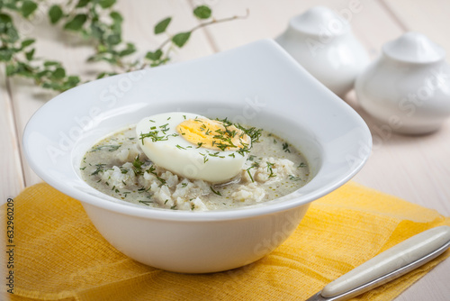 Sorrel soup with egg in white bowl.