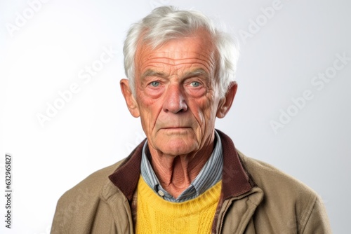 Medium shot portrait photography of a man in his 80s with furrowed brows and a tense expression due to hypertension wearing a chic cardigan against a white background  © Leon Waltz