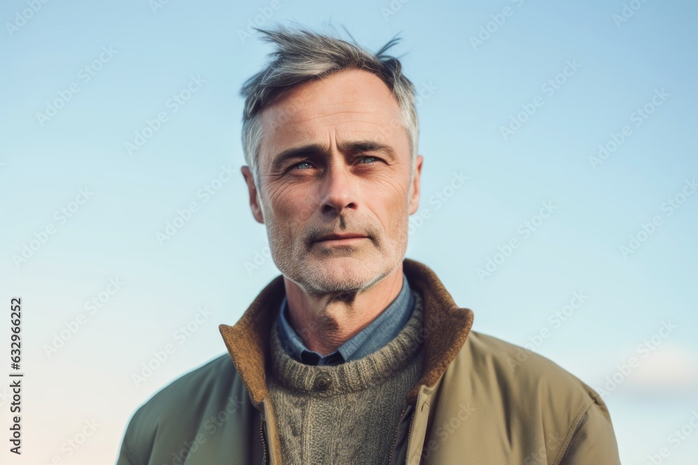 Medium shot portrait photography of a man in his 50s with furrowed brows and a tense expression due to hypertension wearing a chic cardigan against a sky background Medium shot portrait photography of a man in his 50s with furrowed brows and a tense expression due to hypertension wearing a chic cardigan against a sky background