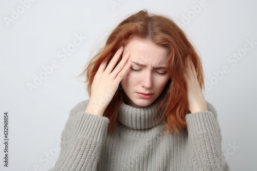 Medium shot portrait photography of a woman in her 30s appearing weakened and pale because of anemia wearing a cozy sweater against a white background  photo