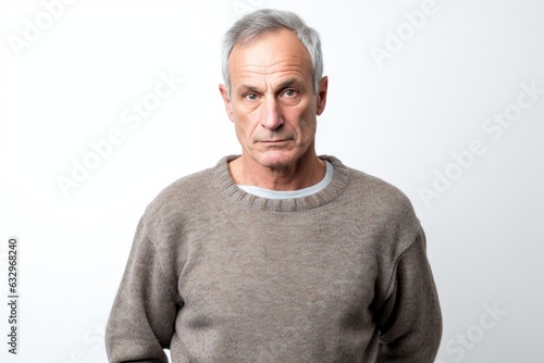Group portrait photography of a man in his 50s appearing weakened and pale because of anemia wearing a cozy sweater against a white background  © Leon Waltz