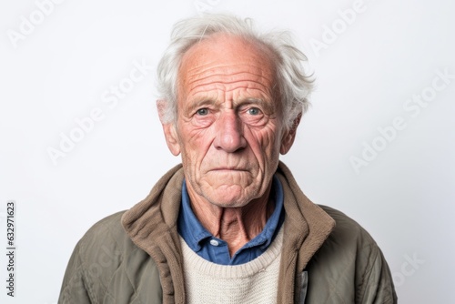 Medium shot portrait photography of a man in his 60s with a pained and tired expression due to fibromyalgia wearing a chic cardigan against a white background  © Leon Waltz