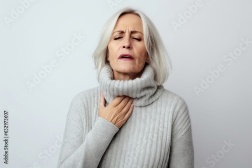 Medium shot portrait photography of a woman in her 40s coughing with discomfort due to pneumonia wearing a cozy sweater against a white background 