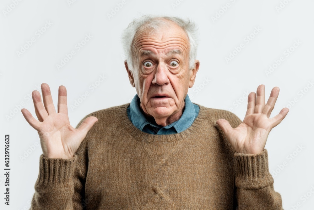 Medium shot portrait photography of a man in his 80s with a trembling hand and pained expression due to Parkinson disease wearing a cozy sweater against a white background Medium shot portrait photography of a man in his 80s with a trembling hand and pained expression due to Parkinson disease wearing a cozy sweater against a white background