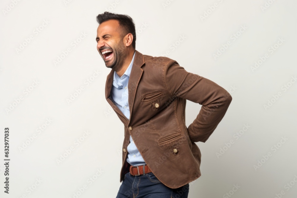 Medium shot portrait photography of a man in his 30s wincing with pain and holding his lower back due to sciatica wearing a chic cardigan against a white background Medium shot portrait photography of a man in his 30s wincing with pain and holding his lower back due to sciatica wearing a chic cardigan against a white background
