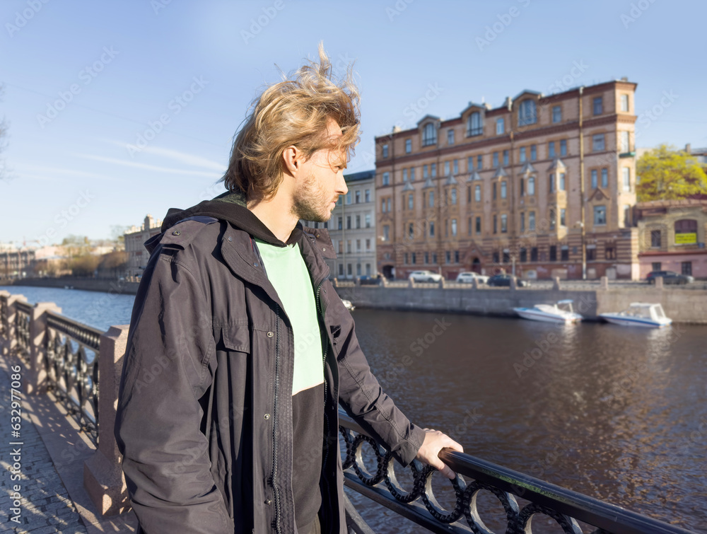 Lifestyle portrait of a young man using a smart phone outdoors.